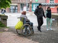 UZHHOROD, UKRAINE - MAY 04, 2020: Image of homeless beggar woman in wheelchair outdoors in Uzhhorod city