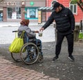 UZHHOROD, UKRAINE - MAY 04, 2020: Image of homeless beggar woman in wheelchair outdoors in Uzhhorod city