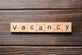 Vacancy word written on wood block. Vacancy text on wooden table for your desing, concept