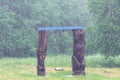 Vacant children swing on green forest glade at summer under heavy rain shower. Raindrops viewed as water threads due to long