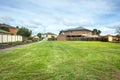 A vacant land with green grass/lawn surrounded by suburban houses in a Melbourne`s suburb. VIC Australia. Royalty Free Stock Photo