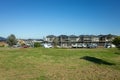 A vacant lot of land with grass lawn with some new townhouses under construction in the background. Royalty Free Stock Photo