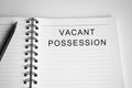 Vacant possession text written on a notepad with a pen