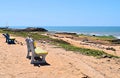Vacant Wooden Benches on Sandy Beach facing Blue Ocean with Open Sky in Hot Summer - Chorwad, Gujarat, India - Emptiness Royalty Free Stock Photo
