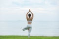 Vacation of Beautiful Attractive Asian woman relaxing in yoga lotus pose on green grass and beach with beautiful sea Royalty Free Stock Photo