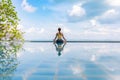 Vacation of Beautiful Attractive Asian woman relaxing in yoga lotus pose on the pool above the beach Royalty Free Stock Photo