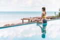 Vacation of Beautiful Attractive Asian woman relaxing in yoga lotus pose on the pool above the beach with beautiful sea Royalty Free Stock Photo