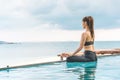 Vacation of Beautiful Attractive Asian woman relaxing in yoga lotus pose on the pool Royalty Free Stock Photo