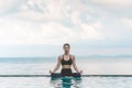 Vacation of Beautiful Attractive Asian woman relaxing in yoga lotus pose on the pool Royalty Free Stock Photo