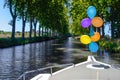 Vacation boat with balloons in Canal du Midi, family travel river cruise by barge penichette, holidays in France