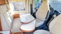 Vacation campervan with luxury white interior table wooden and seat in modern motor home during vanlife concept Royalty Free Stock Photo