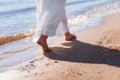 Vacation concept. Close up of female legs walking by the beach. Feet in the water summer. Love story. Waves and sand Royalty Free Stock Photo