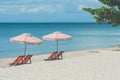 Vacation Concept : Four red wooden chairs and two beach umbrella setting on white sand with seascape in the backgroun