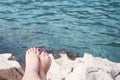 Vacation Concept. Tanning on the Beach. Woman`s Bare Feet over Sea background Royalty Free Stock Photo