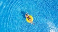 Vacation concept. Top view of slim young woman in bikini on the yellow air inflatable ring in the big swimming pool. Royalty Free Stock Photo