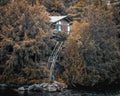 Vacation cottage between autumn trees and stairs to access the lake Royalty Free Stock Photo