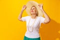 Studio shot of fashionable senior woman in summer style outfit isolated on bright yellow background. Concept of beauty Royalty Free Stock Photo