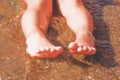 Vacation and holidays concept. Close up feet of two young girls relaxing on beach enjoying sun and sea on sunny summer day Royalty Free Stock Photo