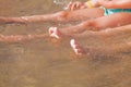 Vacation and holidays concept. Feet of two young girls relaxing on beach enjoying sun and sea on sunny summer day. Selective focus Royalty Free Stock Photo