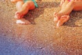 Vacation and holidays concept. Feet of two young girls relaxing on beach enjoying sun and sea on sunny summer day Royalty Free Stock Photo