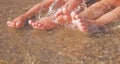 Vacation and holidays concept. Funny image of feet of two young girls relaxing on beach enjoying sun and sea on sunny summer day Royalty Free Stock Photo
