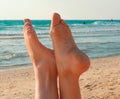 Vacation holidays. Woman feet closeup relaxing on beach on sunbed enjoying sun. Sunny summer day