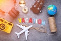 vacation ideas concept with travel stuffs camera ukulele headphone,plane,globe,compass with wwoden text word on grey leather back Royalty Free Stock Photo