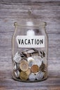 Vacation, money jar with coins on wood table Royalty Free Stock Photo