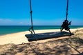 wooden swing over beautiful tropical beach, soft wave hitting sandy beach under bright sunny day. Royalty Free Stock Photo