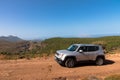 A white Jeep Renegade is parked on a dirt road. All wheel drive.