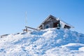 Vacation rural winter background. Small wooden alpine house covered with snow