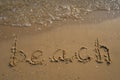 Vacation on the sand beach concept. Beach words written into the sand on the beach. Royalty Free Stock Photo