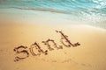 Vacation on the sand beach concept. Sea words written into the sand on the beach. Royalty Free Stock Photo