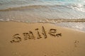 Vacation on the sand beach concept. Smile words written into the sand on the beach at Rayong, Thailand Royalty Free Stock Photo