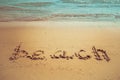 Vacation on the sand beach concept. Beach words written into the sand on the beach. Royalty Free Stock Photo