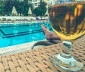 Vacation at sea on the beach. a man sunbathes on a lounger near the pool. on the table is a glass with beer, wheat alcoholic drink Royalty Free Stock Photo