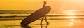 Vacation Silhouette Of A Surfer Carrying His Surf Board Home At Sunset With Copy Space BANNER, long format Royalty Free Stock Photo