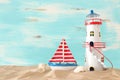 Vacation and summer concept with vintage boat, starfish, lighthouse and seashells over beach sand infront of pastel blue Royalty Free Stock Photo