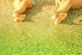 Vacation and summer holidays concept. Feet of two young girls relaxing on beach enjoying sun and sea on sunny day Royalty Free Stock Photo