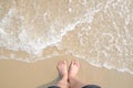 Vacation on summer ocean beach, feet on sea sand with bubble float wave Royalty Free Stock Photo