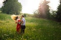 Vacation on the sunny meadow of the happy hugging couple in love. The charming young girl is shaking her long curly