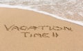Vacation Time written in sand with sea surf Royalty Free Stock Photo