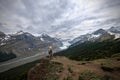 Brave man hiker on mountain top looking at view of Columbia Icefied glacier and moraine lake Royalty Free Stock Photo