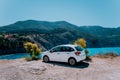 Vacation travel with car concept. Rental hired car in front of amazing bay with turquoise water. Discover Mediterranean Islands. Royalty Free Stock Photo