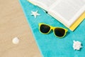 Sunglasses and book on beach towel on sand Royalty Free Stock Photo