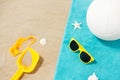 Sunglasses, sand toys and ball on beach towel Royalty Free Stock Photo