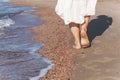 vacation travel - woman leg closeup walking on white sand relaxing in beach cover-up pareo beachwear. and tanned legs. Royalty Free Stock Photo