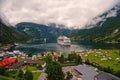 Vacation, trip, wanderlust. Ship in norwegian fjord on cloudy sky. Ocean liner in village harbor. Travel destination Royalty Free Stock Photo