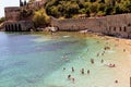 Vacationers bathe and sunbathe against the background of the ancient fortress wall Alanya, Turkey