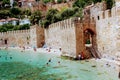 Vacationers bathe and sunbathe against the background of the ancient fortress wall Alanya, Turkey